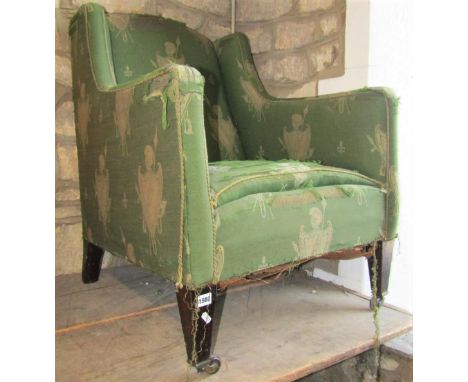 An Edwardian easy chair with shaped outline, upholstered finish and square tapered forelegs, with brown ceramic castors (for 