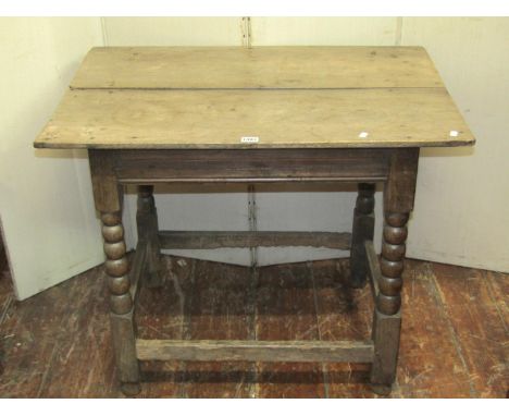 An 18th century oak side/occasional table, the rectangular overhanging two plank top raised on turned bobbin and block legs u