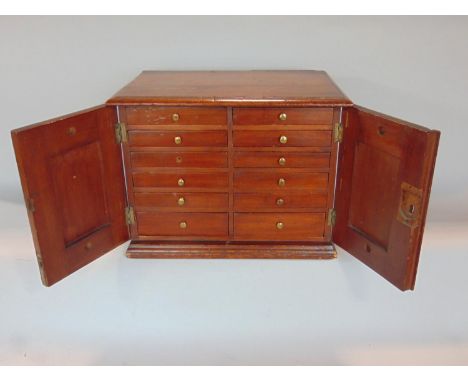 A good late Victorian mahogany table top specimen cabinet, the moulded top over twin doors, enclosing twelve specimen drawers