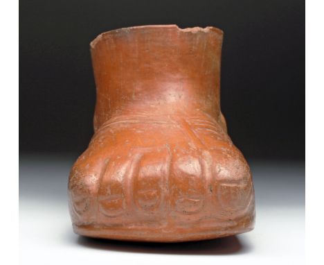 Pre-Columbian, northern Peru, ca. 200 to 600 CE.  Almost life-size jar in the form of a sandaled human foot.  Covered in thic