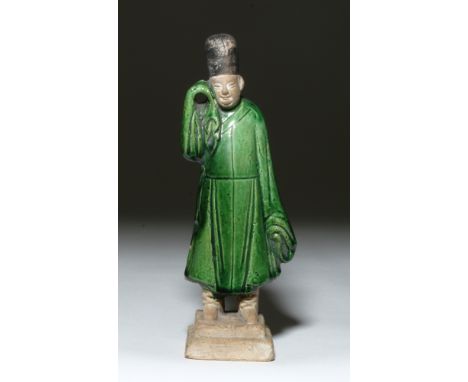 China, Ming Dynasty, ca. 1368 to 1644 CE. Green glazed, molded ceramic figure of a man wearing a green robe and a fez-like ha