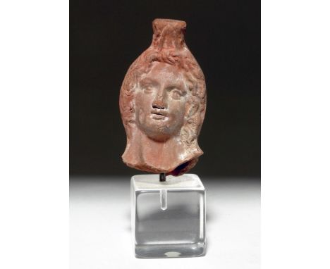 Roman Empire, ca. 1st to 3rd century CE. A poignant mold-made ceramic visage representing the god Apollo, the face subtly tur