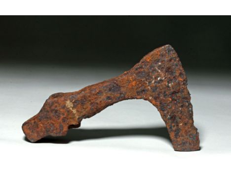 Roman, ca. 0 to 450 CE. This is a hammered iron axe blade with a long, hooked blade, and an oval hole for a wood handle. Iron