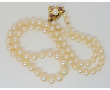 PEARLS WITH A 14K RUBY AND PEARL CLASP the light cream coloured pearls with a good lustre, are tapered from 8.4mm to 5mm. Ove