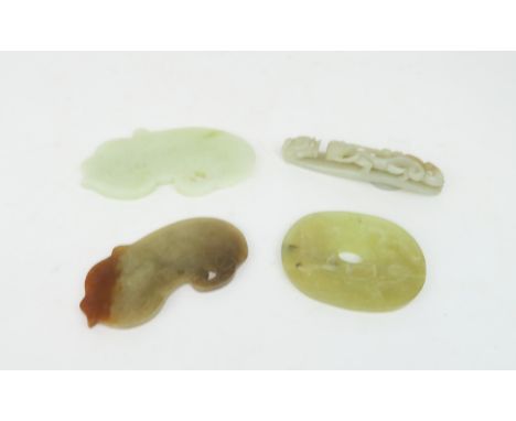A CHINESE JADE BUTTON HOOK Carved with a chilong, 9.5cm long and three modern hardstone carved discs, 7, 8 and 10cm wide (4) 