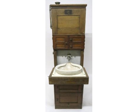 A 19/20TH CENTURY TEAK SHIPS CABIN WASH STAND with three asymmetrical cabinet doors over fall front ceramic wash basin, 172cm