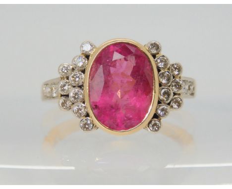 A PINK TOURMALINE AND DIAMOND RING the mount is stamped 750 for 18ct, and set with a 10.8mm x 8.3mm x 5.3mm pink tourmaline, 