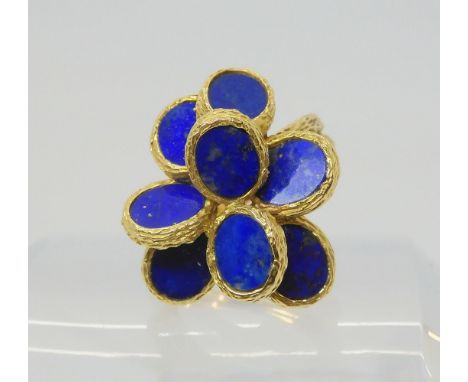 A RETRO LAPIS LAZULI RING the bark textures ring has flat planes of lapis lazuli set win a flower formation, hallmarked with 