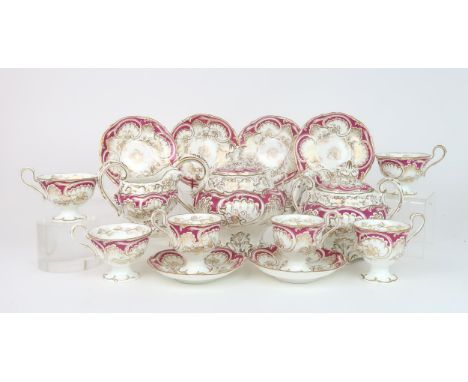 A ROCKINGHAM STYLE TEASET of moulded rococo design, the white ground with gilt vine and grape decoration with magenta pink bo