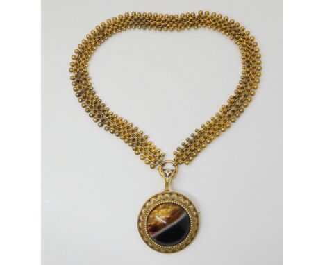 A VICTORIAN AGATE PENDANT craftsman made in yellow metal mounted with a banded agate, with blue and white enamel decoration, 