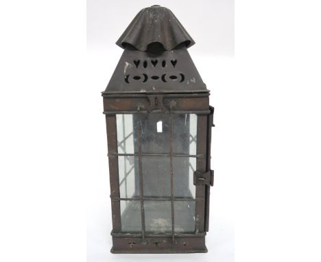 AN EARLY 20TH CENTURY ARTS &amp; CRAFTS CANDLE LANTERN with swing handle over pierced decoration over wire framed glass windo