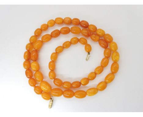 A STRING OF AMBER BEADS largest bead 18mm x 12.4mm, smallest 13.3mm x 9.4mm, overall length 79cm, weight 51.4gms Condition Re