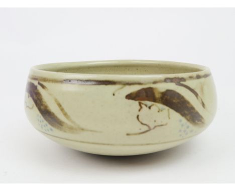 BERNARD LEACH (1887-1979) A stoneware pottery bowl, painted with scrolling decoration in brown, with blue dots, on a cream gr