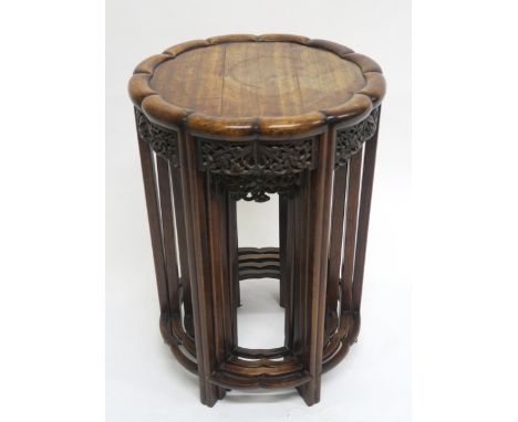 A 19TH CENTURY CHINESE HARDWOOD CIRCULAR NEST OF FOUR TABLES with shaped circular tops over carved floral fretwork friezes on