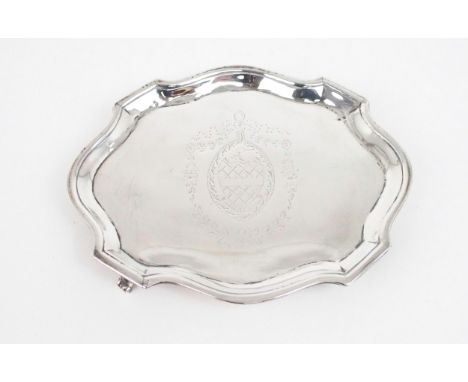 A GEORGE III SILVER TEAPOT STAND of shaped oval form, the centre with engraved crest, on four bracket feet, by Elizabeth Jone