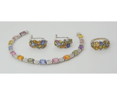 A SAPPHIRE TUTTI FRUITI SUITE comprising of earrings, ring and bracelet. The 18ct white gold bracelet is set with oval sapphi