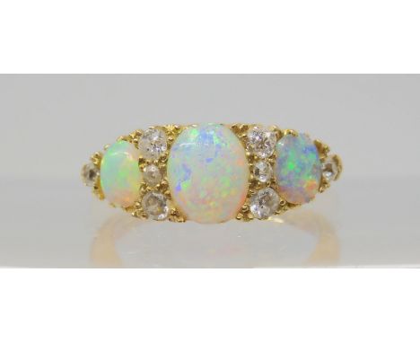 A VINTAGE OPAL &amp; DIAMOND RING with an 18ct gold galleried mount. Largest opal approx 7mm x 5.5mm, the side ones approx 4.