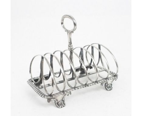 A WILLIAM IV SILVER SIX DIVISION TOAST RACK the divisions double loop shaped, the shaped rectangular body with a gadrooned ri