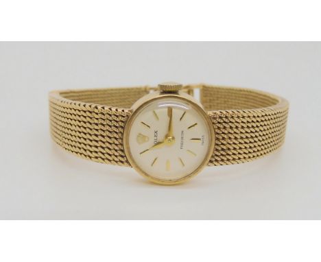 A 9CT GOLD LADIES ROLEX PRECISION white dial with gold coloured baton numerals and hands, with 9ct gold integral strap. Inner