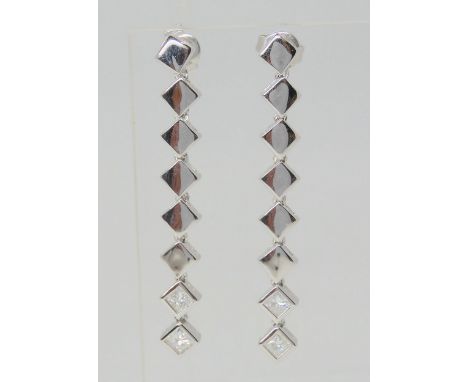 A PAIR OF PRINCESS CUT DIAMOND DROP EARRINGS mounted in 18k white gold, each princess cut diamond is estimated approx at 0.15