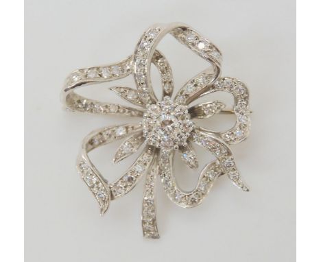 A DIAMOND FLOWER BROOCH set through out in 18ct white gold, the central diamond is estimated approx 0.20cts with a ring of br