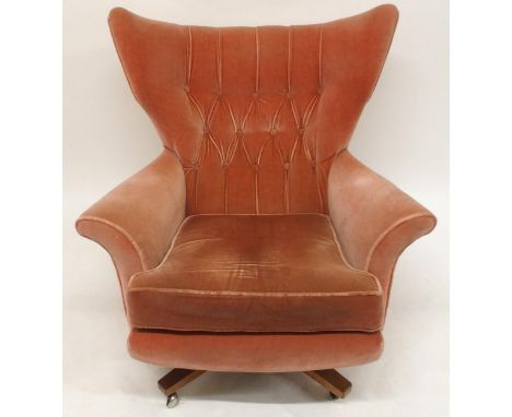 A MID 20TH CENTURY G PLAN MODEL 6250 SWIVEL WING BACK ARMCHAIR with pick velour button back upholstery on teak swivel base, 9