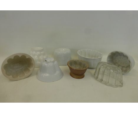 An assortment of ceramic and glass jelly moulds of various styles.