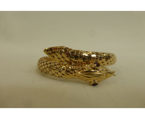 An 18ct gold bangle in the form of a snake with ruby eyes, stamped 750, approximate weight 25.3g.