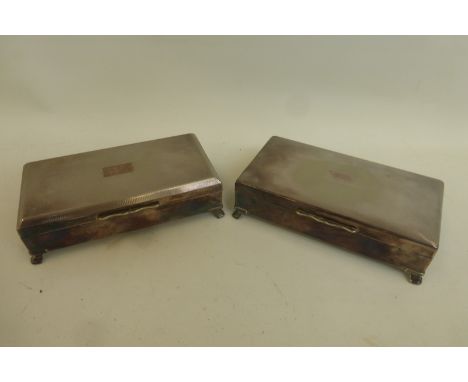 A pair of silver plated cigarette boxes with engine turned decoration to the lids.