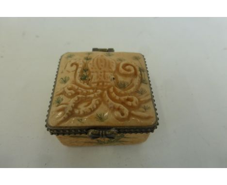 A bone lidded trinket/pill box decorated with a carved octopus.