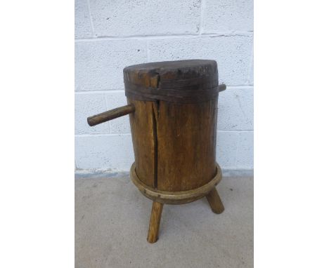 A ship's wooden mooring block converted to an occasional table, raised on a tripod base.
