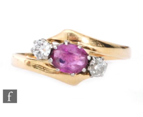 An 18ct ruby and diamond three stone ring, central oval claw set ruby flanked by a diamond to each side, all to a slight twis