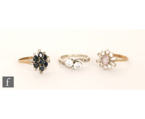 A modern sapphire and diamond sapphire and diamond cluster ring, seven sapphires within an eight stone diamond surround, all 