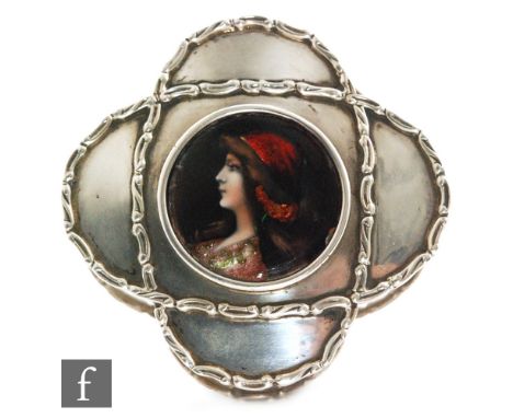 An Edwardian hallmarked silver quatrefoil shaped box with C scroll borders around central circular enamel panel detailed with
