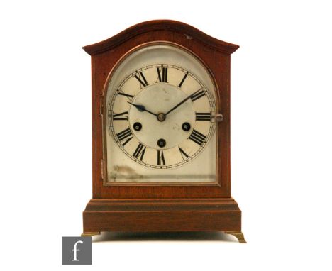 An Edwardian walnut cased mantle clock  in serpentine outline case, silvered arched Roman numeral dial enclosed by a bevelled