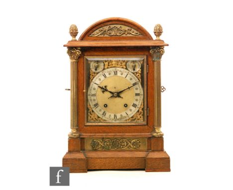 An early 20th Century oak cased eighth day strike mantle clock silvered chapter ring with Roman numerals to a brass dial betw