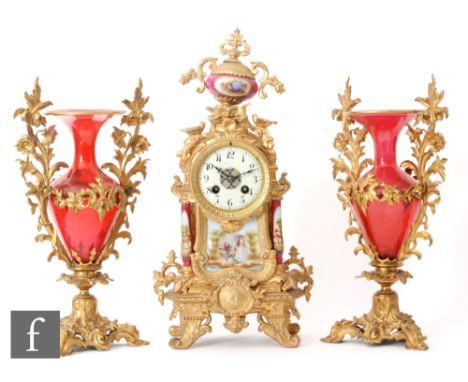 A pair of ruby glass and gilt ormolu vases, the ormolu stands with floral details and raised side handles encompassing Romane