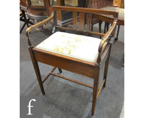 An early 20th Century line inlaid rail back piano stool, with inset panels to the rail over a lift-up seat and a stretcher fr