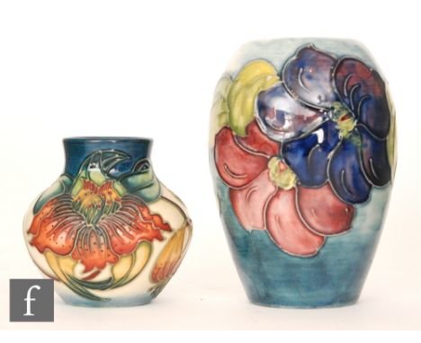 Two Moorcroft vases, the first decorated in the Clematis pattern with tubelined flowers against a pale blue wash ground, impr