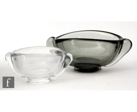 A pair of post war Orrefors graduated bowls, both of footed oval form with applied handles to two ends, the smaller clear and