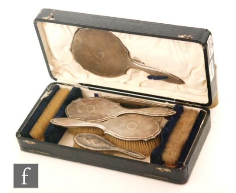 A cased hallmarked silver backed six piece brush set with engine turned decoration around engraved initials and date, London 