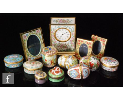 A collection of Halycon Days enamels, to include pill or patch boxes for years 1990, 1991, 1992, a mantle clock with a floral