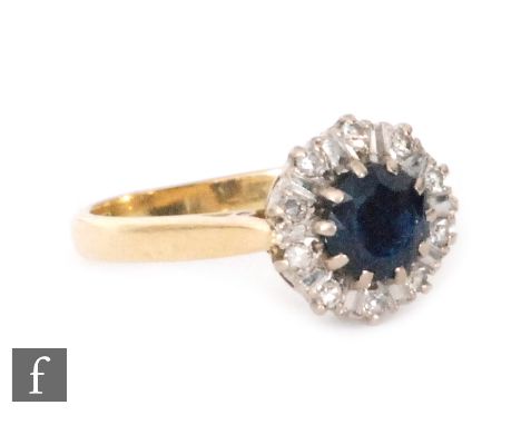 A mid 20th Century 18ct hallmarked sapphire and diamond cluster ring, central sapphire within a ten stone diamond surround, r