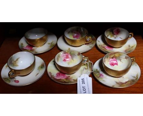 Six miniature hand painted Royal Worcester cabinet cups and saucers decorated with roses and a gilt exterior.