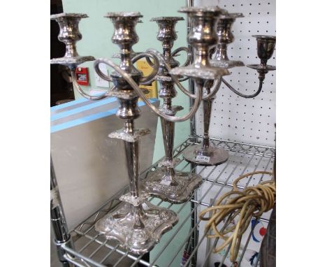 A pair of silver plated three light table candelabra with one other similar