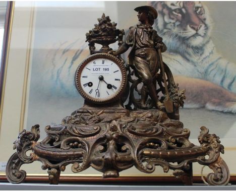 A 19th century patinated cast metal mantel clock, decorated with a gardener, having bell strike, with key