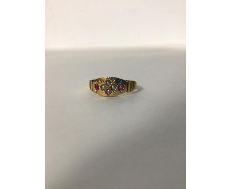 A 15ct gold ring, the oval panel set four seed pearls flanked by two coloured stones (2.1g) (N)