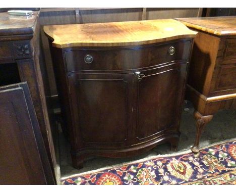 A reproduction Georgian inspired side cabinet, with serpentine top, fitted frieze drawer and two cupboard doors enclosing she