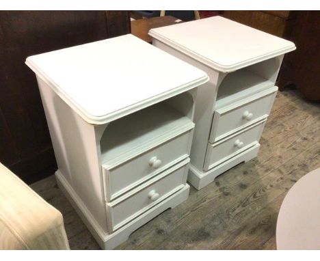 A pair of modern white painted bedside tables, the rectangular tops with moulded edges, with recess above two drawers, on bra