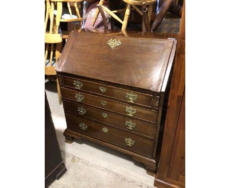 A Georgian mahogany bureau, the fall front enclosing an arrangement of drawers and pigeonholes, above four graduated drawers 
